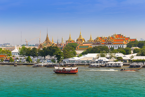 The Chao Phraya River in Bangkok with a temple on the background