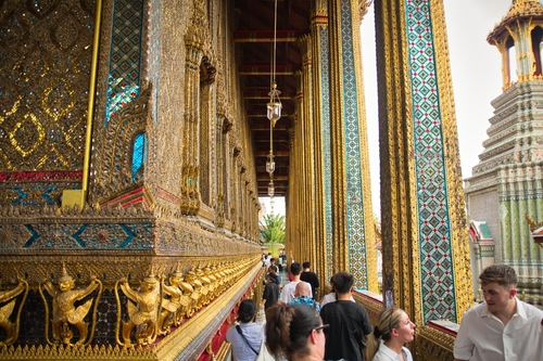 Interior of the Grand Palace with tourists walking around , Wat Phra Kaew, Temple of the Emerald Buddha, one of the most famous tourist places in Bangkok, Thailand