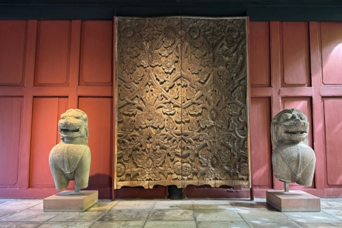 The Jim Thompson House Museum. Two lion statues placed in front of ancient Thai carved wood, Bangkok, Thailand