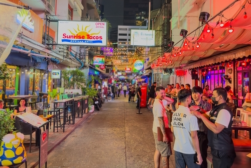 Patpong night market in Silom Bangkok at night colourful neon lights of the clubs and bars and vendors selling their stock, Thailand