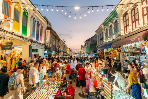 Tourists are walking on the Phuket Walking Street is a night market that takes over the beautiful Thalang Road in Phuket Old Town every Sunday evening, Thailand