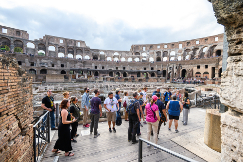 A group of tourists enjoying a tour of the Colosseum or Coliseum in Rome, Lazio, Italy