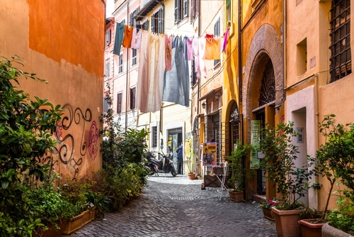 Narrow street view with a laundry line in the center of the image in the Trastevere district in Rome, Lazio, Italy
