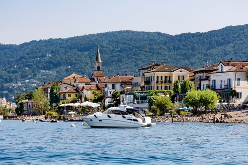 Pleasure boat on Lake Maggiore and the Isola dei Pescatori - beautiful island is one of the Borromean islands, 400 meters north of Stresa, Lombardy, Italy