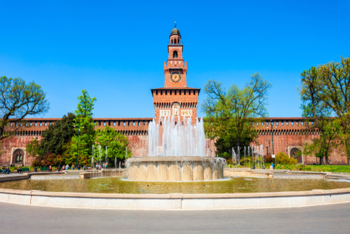 Exterior view of Sforza Castle or Castello Sforzesco and a fountain located in Milan, Italy