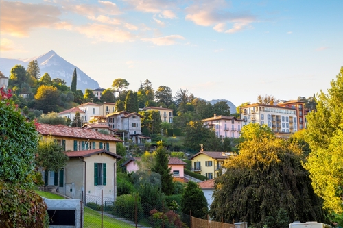 Homes and villas line the hills above the small fishing village of Pescallo, Como lake, Lombardy, Italy
