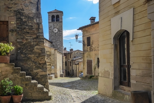Scenic view from Medieval towns and castles of Emilia Romagna, Italy. Castel Arquato town and Rocca Viscontea castle on hill surrounded by greenery. Tranquil and calm scenery. Clear blue sky