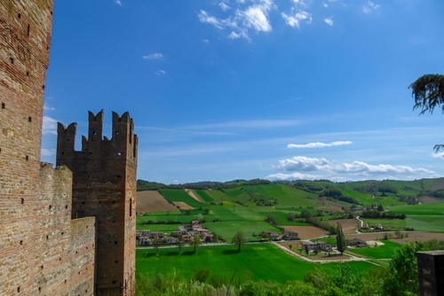 Scenic view from Medieval towns and castles of Emilia Romagna, Italy. Castel Arquato town and Rocca Viscontea castle on hill surrounded by greenery. Tranquil and calm scenery. Clear blue sky