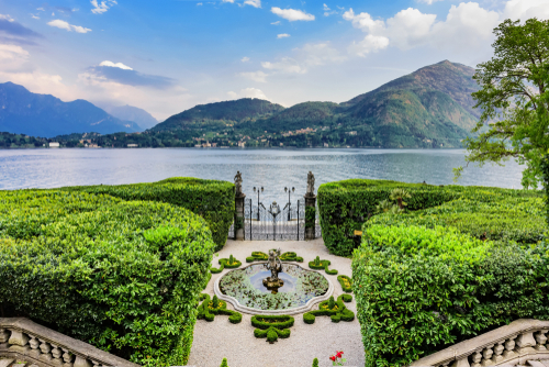 The central gate and fountain at the entrance to the Villa Carlotta. View of Lake Como and the surrounding mountains, Tremezzina, Lake Como, Lombardy, Italy