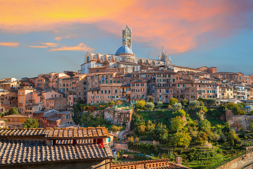 Siena, an amazing medieval town at sunset with view of the Dome & Bell Tower of Siena Cathedral (Duomo di Siena), landmark Mangia Tower and Basilica of San Domenico, Tuscany, Italy