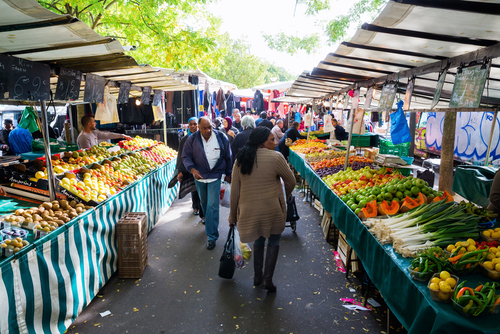 Street market in Belleville with unidentified people. Its a large and popular outdoor market along Boulevard de Belleville with many local farmers selling their produce, Paris, France