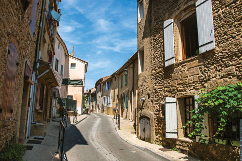Street view with stone houses in the center of the village of Chateauneuf-du-Pape, blue sky and sunny day. Located in the Vaucluse department, Provence, France