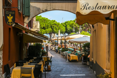 View of restaurants and narrow-cobbled streets in the town of Desenzano del Garda, located on the banks of La Garda Lake, Lombardy, Northern Italy