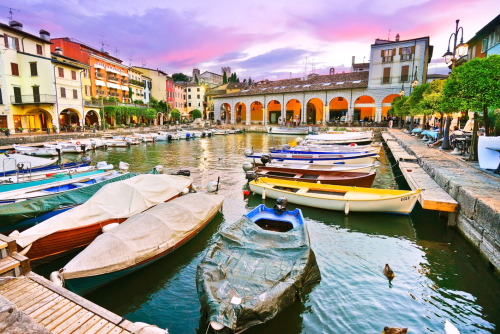 Old harbour full of boats in Desenzano del Garda, Brescia, Lombardy, Italy. City Centre of Desenzano del Garda. marina on Lake Garda