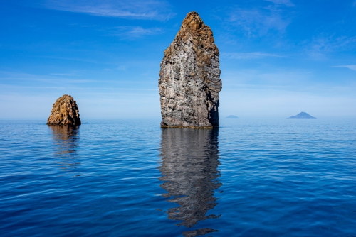View from a boat of the fantastic Faraglioni rock needles in front of the island of Lipari, Aeolian Islands, near Sicily, Italy