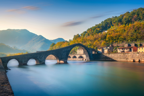 Bridge of the Devil or Ponte della Maddalena historic landmark in Garfagnana, Serchio river, Borgo a Mozzano, Lucca, Tuscany, Italy. Long Exposure in Autumn