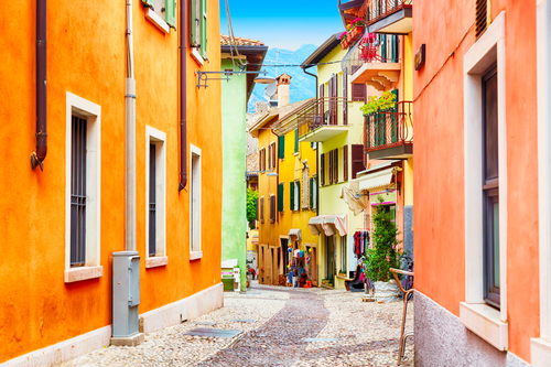 Small town narrow street view with colorful houses in Malcesine, La Garda Lake, Veneto, Italy, during a Sunny day