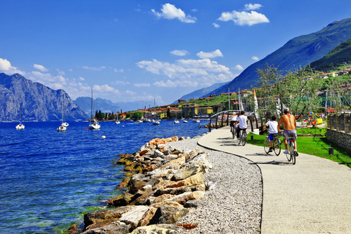 People riding along the promenade in the town of Malcesine, La Garda Lake, Veneto, Italy