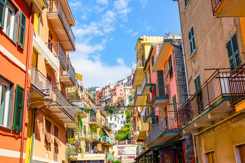 View of the colorful houses along the main street in a sunny day in Manarola. Manarola is one of the five famous Cinque Terre villages in natiolal park, Liguria, Italy