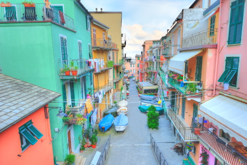 View of the colorful houses along a street in a sunny day in Manarola. Manarola is one of the five famous Cinque Terre villages in natiolal park, Liguria, Italy