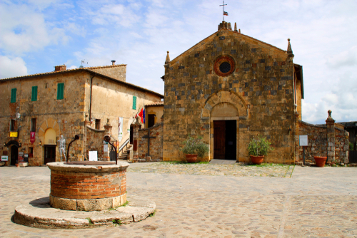Church and water well in Monteriggioni town, Tuscany, Italy