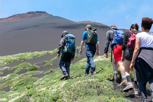 Tallest active volcano of Europe 3329m in Italy. Hikers moving on the land of the Etna volcano in Sicily, Italy