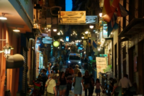 People walking through a crowded street at night in Naples, Campania, Italy