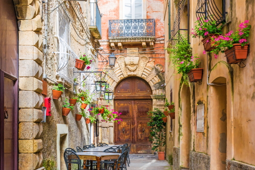 Cafe tables and chairs outside in an old cozy street in Positano, Amalfi Coast, Campania, Italy