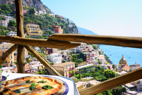 Pizza in a restaurant terrace overlooking to the beautiful Positano, Amalfi Coast, Campania, Italy