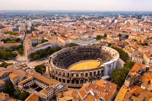 Aerial view of historical area of French city of Nimes overlooking restored antique Roman amphitheatre on sunny autumn day, Provence, France
