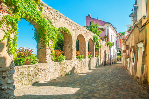Beautiful old stone wall with arches and flowers on old European street, Ravello, Amalfi coast, Campania, Italy