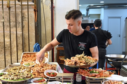 Fish seller in a market in Palermo, Sicily, Italy