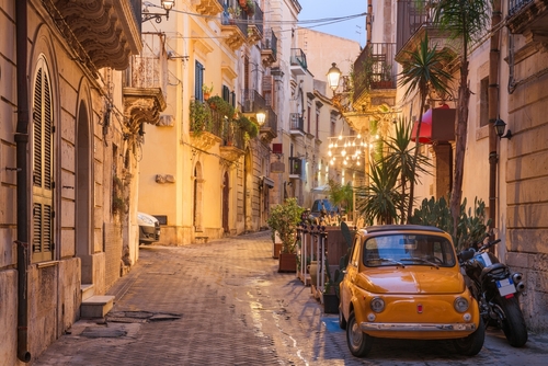 Cityscape and street scene at twilight in Syracuse, Sicily, Italy
