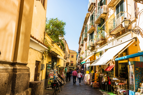 Couple walking on a narrow street with local shops in Sorrento, Amalfi Coast, Campania, Italy