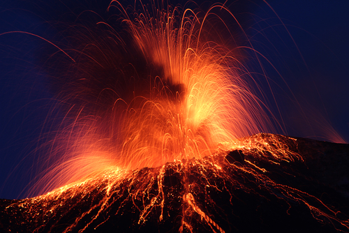 Night eruption volcano on Stromboli Island, the Aeolian Islands, Sicily, Italy. Glowing rocks falling down