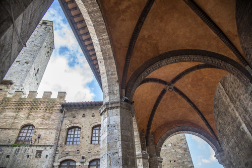 Interior view of the loggias and Torre Chigi (Chigi Tower) in the cathedral square of San Gimignano, Val d'Elsa, Tuscany, Italy