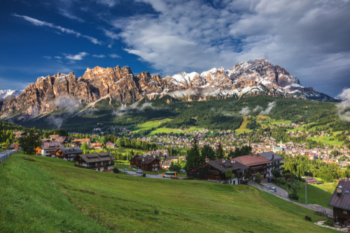 Cortina d'Ampezzo town panoramic view with alpine green landscape and massive Dolomites Alps in the background in the province of Belluno, South Tyrol, Trentino Alto Adige, Italy