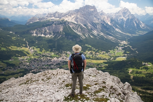 Man hiker admiring the stunning beauty of impressive peaks of Sorapis mountain group in Dolomites, Italy