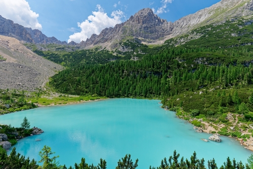View of the blue turquoise Lake Sorapis, Lago di Sorapiss, with mountains in the background of the Dolomites mountains, Trentino Alto Adige, Italy. One of the most beautiful lakes in Italy