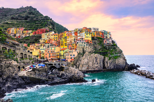 Colorful traditional houses on a rock over Mediterranean sea on dramatic sunset, Manarola, Cinque Terre, Italy