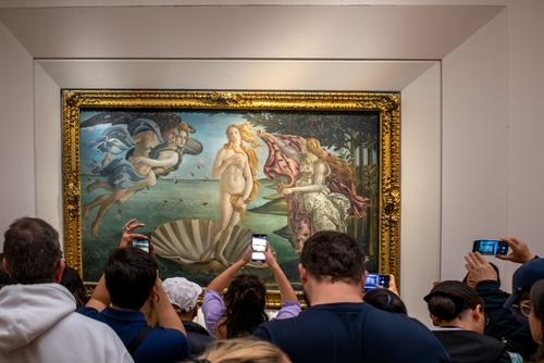 Visitors to the Uffizi Gallery Museum in Florence taking photos in front of the famous painting The Birth of Venus by Sandro Botticelli, Tuscany, Italy
