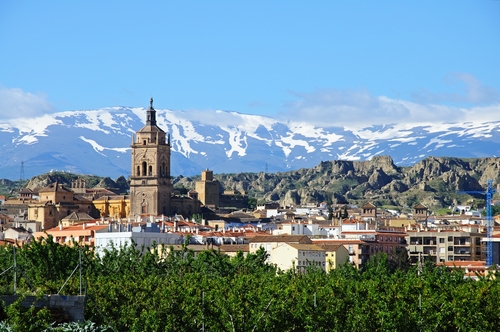 View of a town and Cathedral with the snow capped mountains of the Sierra Nevada to the rear, Guadix, Granada Province, Andalusia, Spain