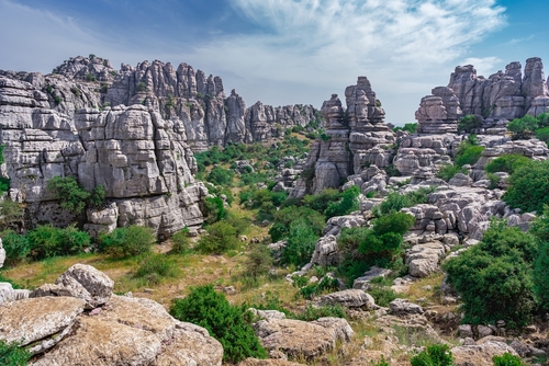 Karst landscape of Torcal de Antequera, Large valley with Mediterranean vegetation surrounded by vertical limestone rock walls, Antequera, near Malaga, Andalusia, Spain