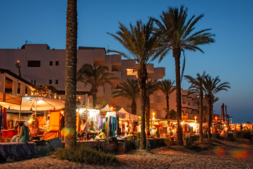 The tourist resort of Es Pujols in the lively and colorful Summer evening, seen from the beach, Formentera island, Balearic Islands, Spain