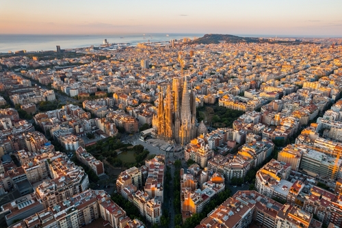Aerial view of Barcelona Eixample residential district and Sagrada Familia Basilica at Sunrise. Catalonia, Spain, cityscape with typical urban octagon blocks
