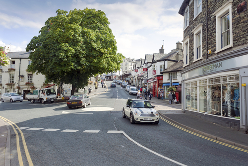 People shopping on Crag Brow a busy street of shops in the tourist town Bowness on Windermere in the Lake District, Cumbria, England, UK