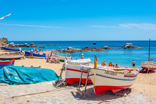 People are enjoying a sunny day at a beach at Calella de Palafrugell, Costa Brava, Catalonia, Spain