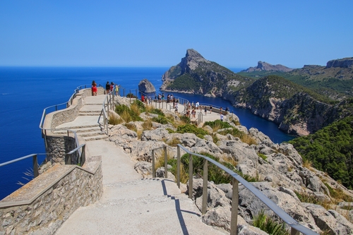 Tourists enjoying a breathtaking view over Cape Formentor at the mirador (