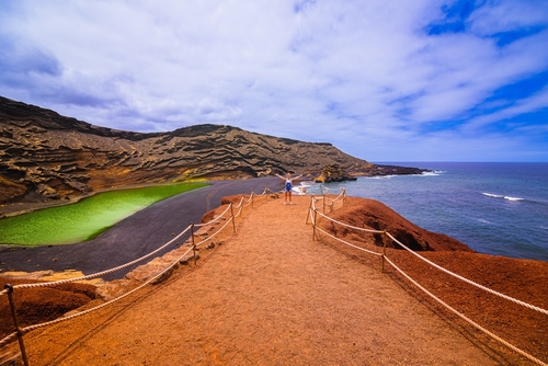 A girl enjoys the beautiful scenery of the Charco de Los Clicos lagoon in Lanzarote Island, The Canary Islands, Spain