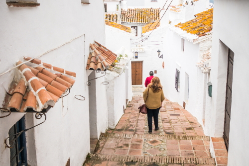 People walking through the streets of Comares, a village of Moorish origin with roofs and whitewashed houses, near Malaga, Andalusia, Spain